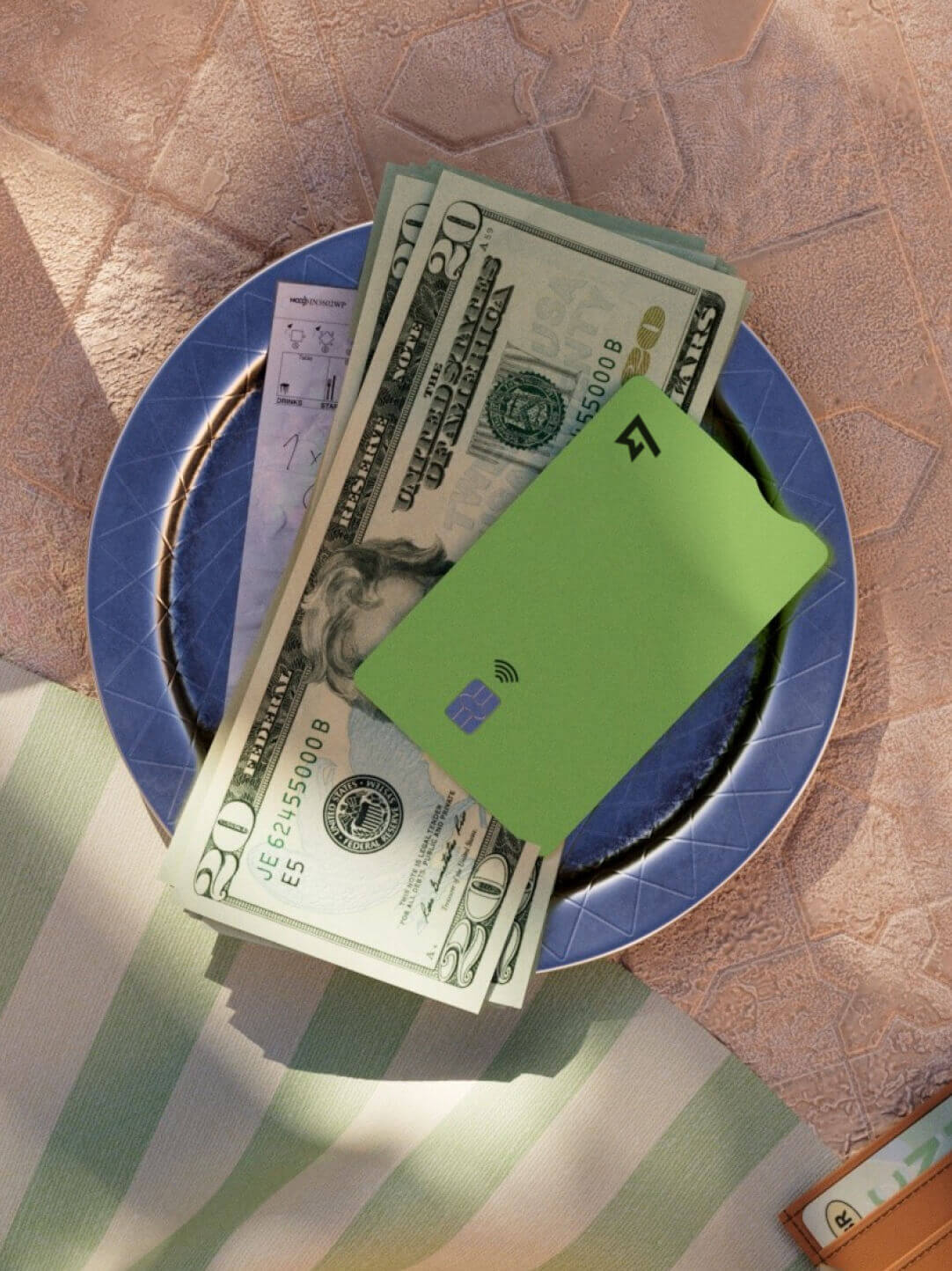 A plate sits on a table, with USD cash and a Wise Multi-Currency Card.