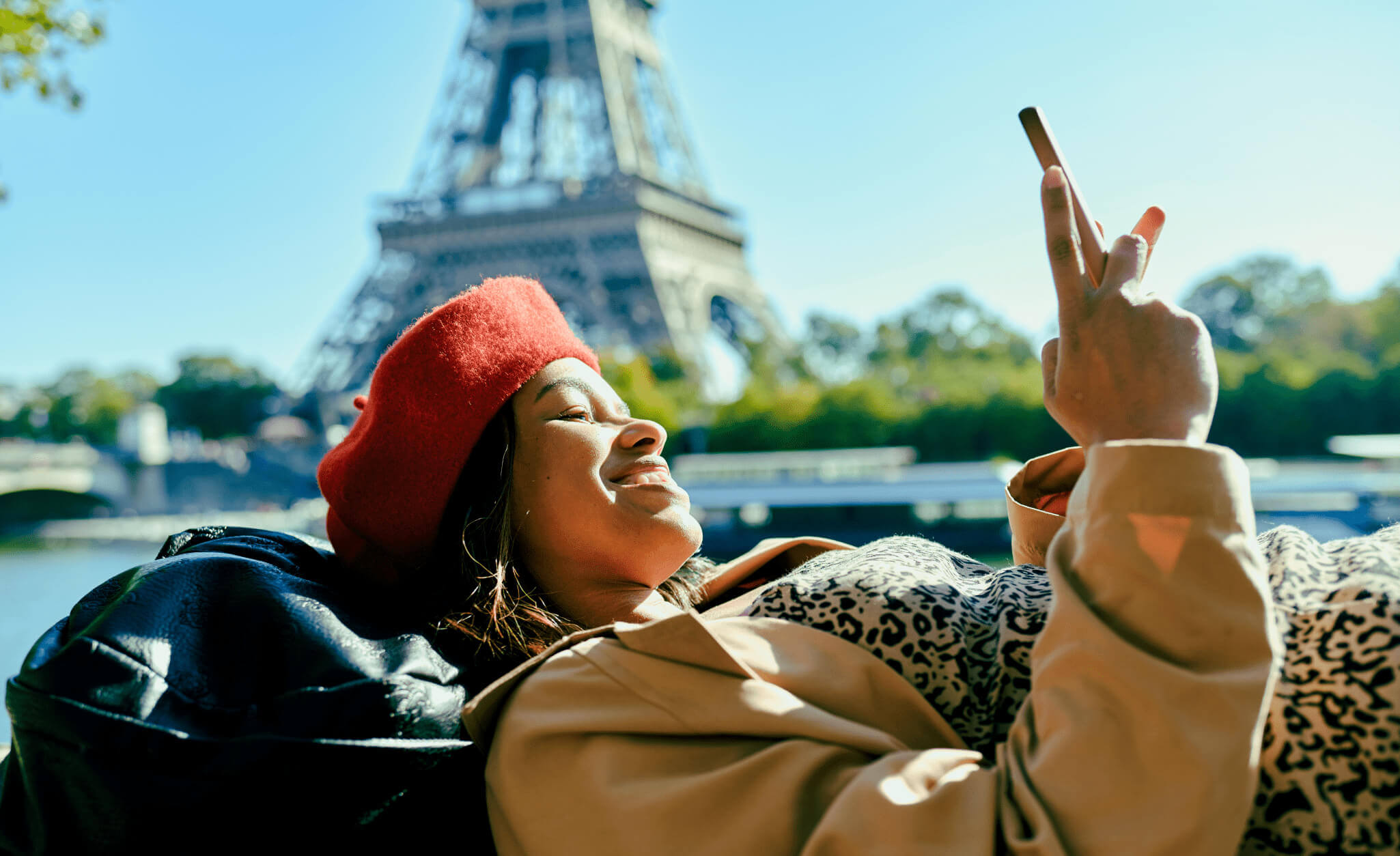 Mulher brasileira usando o telefone em frente à torre Eiffel